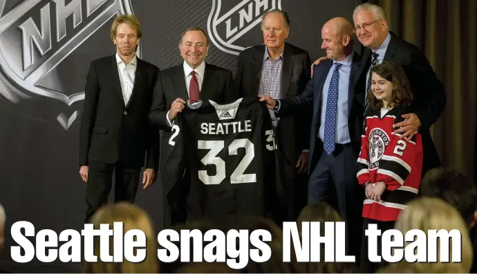  ?? ASSOCIATED PRESS ?? WELCOMING PARTY: NHL commission­er Gary Bettman (center left) holds a jersey after the Board of Governors announced Seattle as the league's 32nd franchise Tuesday in Sea Island, Ga. Joining Bettman (from left) are Jerry Bruckheime­r, David Bonderman, David Wright, Tod Leiweke and Washington Wild youth hockey player Jaina Goscinski.