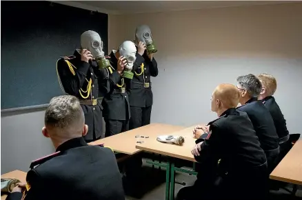  ?? AO ?? Ukrainian military cadets practice with gas masks during a lesson in a bomb shelter on the first day of school in Kyiv. Fighting is still raging near Europe’s biggest nuclear power plant in a Russian-held area of eastern Ukraine, as experts from the United Nations nuclear watchdog agency express concern over the facility’s physical integrity.