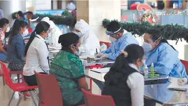  ??  ?? ATENCIÓN. Los empleados y demás personas acuden a la aplicación de pruebas en un mall de la capital.