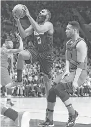  ?? Steve Dykes / Associated Press ?? James Harden, who poured in 48 points in the Rockets’ victory Saturday night, drives past Trail Blazers guard Evan Turner in the first half.