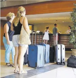  ?? FRANK PALACE ?? Varios turistas esperan para realizar el ‘check in’ en un hotel de Benicàssim.