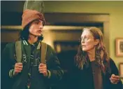  ?? A24 ?? Finn Wolfhard, left, and Julianne Moore in Jesse Eisenberg’s directoria­l debut “When You Finish Saving The World.”