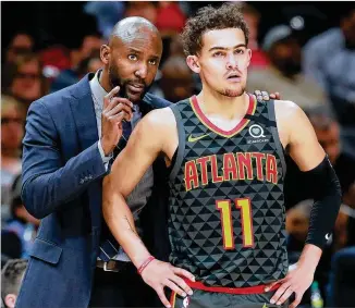  ?? CURTIS COMPTON / CCOMPTON@AJC.COM ?? Coach Lloyd Pierce talks with Trae Young during Tuesday’s win over Phoenix in Atlanta. Young, Kevin Huerter and John Collins have played just 168 minutes together in 12 games.