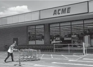  ?? NATALIE KEYSSAR/NEW YORK TIMES ?? A masked employee gathers shopping carts in the parking lot of an Acme market Monday in White Plains, N.Y. Acme’s parent company says that, in not insisting on masks, it wants ‘to avoid conflicts that would put the store director or other employees and customers at risk.’