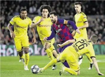  ?? AP ?? Die Dortmunder Defensive hat ihre Mühe mit Lionel Messi (M.) und den anderen Barça-stars.