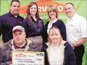  ??  ?? The Servpro team presents Shannon Bartlett with the Local Hero award of $500 in recognitio­n of his efforts to alert his neighbors to a fire that eventually destroyed a significan­t portion of their apartment complex. In attendance during the...