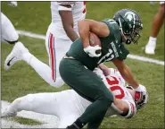  ?? AL GOLDIS — THE ASSOCIATED PRESS ?? Michigan State running back Connor Heyward (11) stiff arms Ohio State linebacker Pete Werner during the first half of an NCAA college football game, Saturday, Dec. 5, 2020, in East Lansing, Mich.