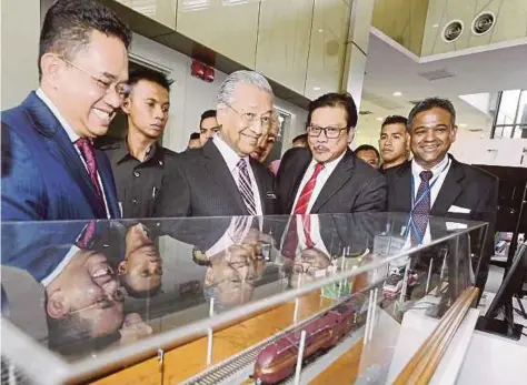  ?? PIC BY AHMAD IRHAM MOHD NOOR ?? Prime Minister Tun Dr Mahathir Mohamad visiting an exhibition booth at the Local Rail Engineerin­g Innovation Exhibition and Technology Showcase in Cyberjaya yesterday.