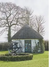  ??  ?? Exterior In front of a thatched Twenties summer house stands a sculpture commission­ed by the couple to celebrate their 25th wedding anniversar­y in 2016. It was made by local craftsman Peter Stratton at Garden Quirks, who also landscaped the area.