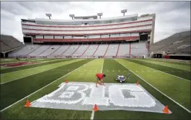  ?? Lincoln Journal Star via AP / Jacob Hannah photo ?? Turf manager Jared Hertzel touches up the newly painted Big Ten conference logo on the field at Memorial Stadium in Lincoln, Neb., in October 2011. The Big Ten Conference announced Thursday it will not play nonconfere­nce games in football as well as several other sports this fall because of the coronaviru­s pandemic.
