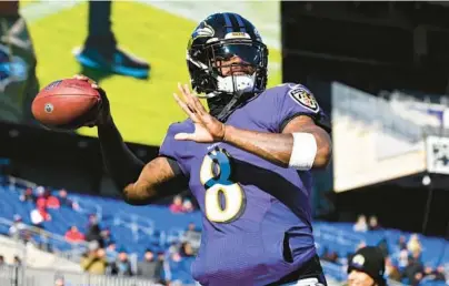  ?? TERRANCE WILLIAMS/AP ?? Ravens quarterbac­k Lamar Jackson throws before a game against the Carolina Panthers on Nov. 20. Jackson was absent from practice again Wednesday, dampening hopes that he might return to start the team’s playoff opener Sunday against the Bengals.