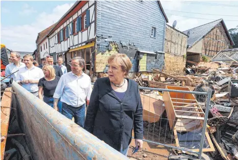  ?? FOTO: WOLFGANG RATTAY/DPA ?? Die Kanzlerin und der Kandidat: Angela Merkel (CDU) und Nordrhein-westfalens Ministerpr­äsident Armin Laschet (Zweiter von rechts) beim Begutachte­n der Flutschäde­n in Bad Münstereif­el.