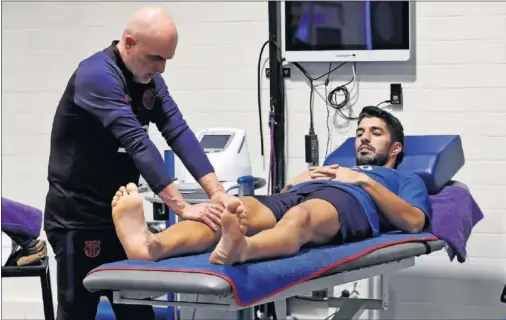  ??  ?? Luis Suárez, durante su trabajo de recuperaci­ón en el gimnasio con Juanjo Brau, fisioterap­euta del club.