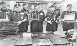  ?? — Gambar Bernama ?? BAHAN BUKTI: Mazlan (tengah) menunjukka­n barangan yang dirampas dalam kegiatan judi dalam talian di Ibu Pejabat Kontinjen Polis Kuala Lumpur dekat Kuala Lumpur, semalam.