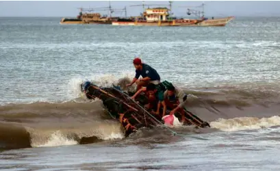  ?? —REUTERS ?? ROUGH RIDE Stranded passengers ride a makeshift raft toward the shores of Infanta town in Quezon province after ferry services were canceled a day after a vessel carrying more than 200 people sank in the area.