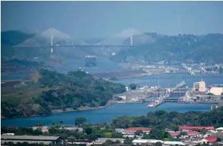  ?? AP PHOTO/AGUSTIN HERRERA ?? A cargo ship waits Wednesday near the Centennial Bridge for transit through the Panama Canal locks, in Panama City.