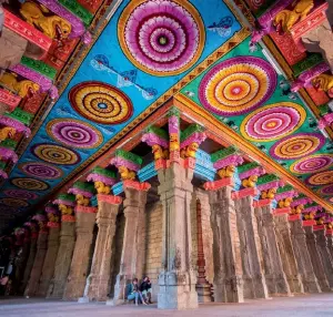  ??  ?? The ceilings and pillars of Meenakshi Amman Temple exhibit colourful art. Below: A tailor stitches umbrellas that are used to decorate the temple chariot.