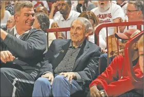  ?? (NWA Democrat-Gazette/Andy Shupe) ?? Former Arkansas Coach Eddie Sutton (center) sits with former Razorbacks Joe Kleine (left) and Darrell Walker during the first half of a game on Jan. 21, 2016, at Bud Walton Arena in Fayettevil­le. Sutton, who died Saturday, transforme­d the Razorbacks into a national power.