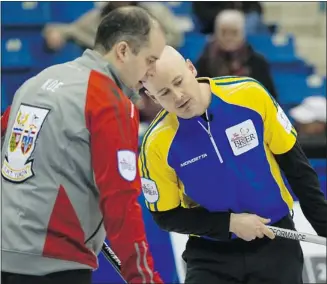  ?? Andy Clark, Reuters ?? Alberta skip Kevin Koe, right, studies a shot along with his brother and N.w.t.-yukon skip Jamie Koe during their match at the Brier on Wednesday. Kevin, from Calgary, won 11-3.