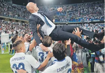  ??  ?? Real Madrid’s French head coach Zinedine Zidane is tossed by players at the end of the Spanish league football match Malaga CF vs Real Madrid at La Rosaleda stadium in Malaga. — AFP photo