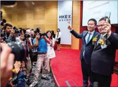  ?? LAWRENCE/AFP ISAAC ?? China Literature Limited co-chief executive officers Liang Xiaodong (second right) and Wu wenhui (right) pose for photos at the company’s Intial Public Offering at the Hong Kong Stock Exchange yesterday.