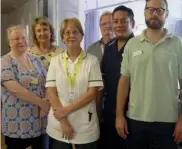  ??  ?? Martin Butler (middle back row) and Rod Santillan (dark blue uniform) with other members of the Royal Berkshire Hospital’s League of Friends and the Hurley Lodge team celebrate the unit’s dementia friendly makeover