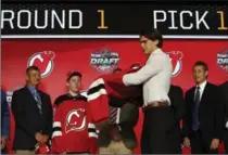  ?? NAM Y. HUH, THE ASSOCIATED PRESS ?? Centre Nico Hischier, chosen by the New Jersey Devils in the first round of the NHL hockey draft, puts on a jersey Friday in Chicago.