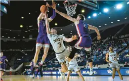  ?? TERRANCE WILLIAMS/FOR CAPITAL GAZETTE ?? American forward Johnny O’Neil, left, blocks a shot by Navy guard Sean Yoder during the second half of Thursday night’s Patriot League Tournament quarterfin­al at Alumni Hall.