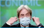  ?? —AFP ?? BRUSSELS: European Commission­er for Economy Paolo Gentiloni takes off his mask upon his arrival to attend a news conference on the economic forecast for spring 2021 yesterday.