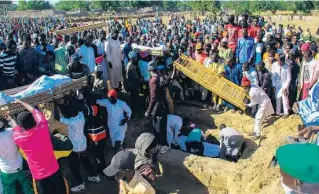  ??  ?? LUTO Quarenta e três vítimas foram enterradas ontem. Todas eram trabalhado­res em campos de arroz