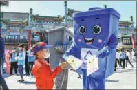  ?? DENG WEI / FOR CHINA DAILY ?? Cartoon mascots help to disseminat­e informatio­n on trash sorting along Qianmen Street in Beijing on May 19.