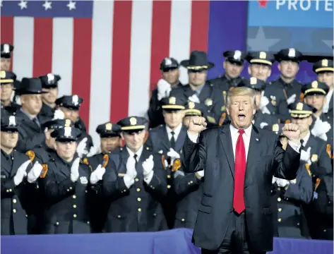  ?? EVAN VUCCI/AP ?? U.S. President Donald Trump pumps his fist after speaking Friday to law enforcemen­t officials about the street gang MS-13 in Brentwood, N.Y. The Senate is sending a package of stiff financial sanctions against Russia to Trump to sign after the bill...