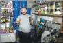  ?? Associated Press ?? Melvin Burton holds up stored provisions in his garden shed in Littleport, Cambridges­hire, England, on Friday.