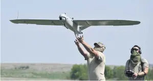  ?? PHOTOS BY AFP ?? Ukrainian servicemen launch a Leleka reconnaiss­ance drone near Chasiv Yar on Saturday.