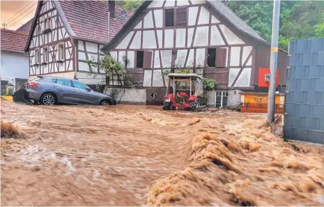  ?? FOTO: SEBASTIAN SCHMITT/DPA ?? In Winterburg ist eine Straße durch das Unwetter überflutet. Unwetter haben Einsatzkrä­ften in Rheinland-Pfalz viel Arbeit beschert. Vielerorts sind dort wie auch im gesamten Bundesgebi­et Straßen und Keller unter Wasser gesetzt.