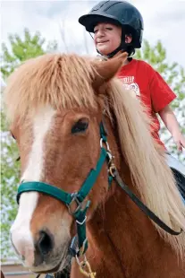  ??  ?? ABOVE: Adriene Jaramillo smiles as he finishes his lesson last week at the New Mexico Center for Therapeuti­c Riding. The lesson was dedicated to teamwork and taking turns as each student led the group in various courses around the arena.