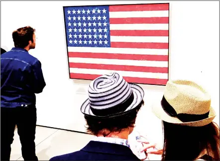  ??  ?? This Feb 7 photo shows journalist­s gather around a flag by artist Jasper Johns, encaustic and collage on canvas during a media preview of The Broad in
Los Angeles. (AP)