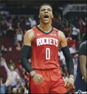  ?? Associated Press ?? DELAYED Houston Rockets guard Russell Westbrook reacts after a dunk against the Minnesota Timberwolv­es on March 10 in Houston. Westbrook tested positive for Coronaviru­s and wasn’t able to join his team in Orlando.