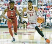  ?? BRANDON SUMRALL/GETTY ?? Alabama’s Brandon Miller, right, drives against Arkansas’ Davonte Davis on Saturday at Coleman Coliseum in Tuscaloosa, Alabama.