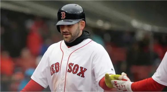  ?? (Photo by Steven Senne, AP) ?? Former Mississipp­i State player Mitch Moreland of the Boston Red Sox is welcomed to the dugout after scoring on a ground-rule double hit by Tzu-Wei Lin in the sixth inning of Sunday’sl game against the Baltimore Orioles.