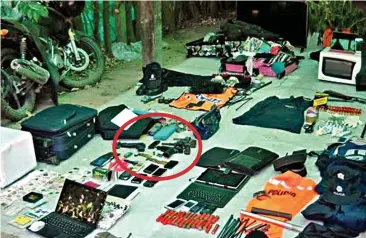  ??  ?? Haul: Items seized by police during the arrests, including guns and ammunition (circled)