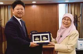  ?? BERNAMA PIC ?? Ambassador of the People’s Republic of China to Malaysia, Bai Tian (left), receiving a souvenir from Deputy Prime Minister Datuk Seri Dr Wan Azizah Wan Ismail during a courtesy call at Parliament.