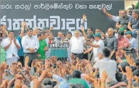  ?? AP ?? Sri Lanka's sacked prime minister Ranil Wickremesi­nghe waves to his supporters along with lawmakers supporting him during a protest rally outside the prime ministers official residence.