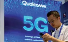  ?? — Reuters ?? Signs of Qualcomm and 5G are pictured at Mobile World Congress (MWC) in Shanghai, China.