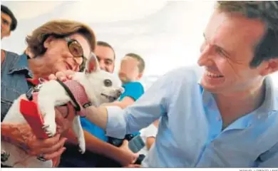  ?? MANUEL LORENZO / EFE ?? Pablo Casado acaricia el perro de una militante en un acto organizado ayer en Alicante.