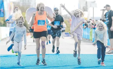  ?? ?? Nouna Chugg set her sights on running a marathon and celebrated at the finish line of the Gold Coast Marathon with her daughters Lilou , Indiana and Emma. Picture: Glenn Campbell