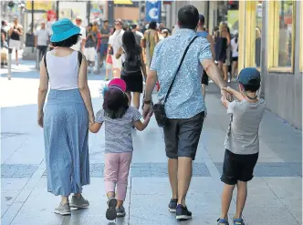  ?? ?? Una familia pasea de la mano por una calle de Madrid.