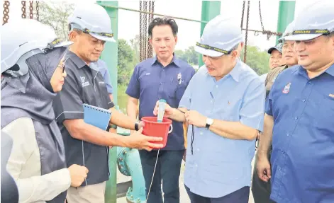  ?? ?? Chief Minister Datuk Seri Panglima Haji Hajiji Haji Noor checking the salinity at the Limbahau EWSS WTP water intake on Tuesday.