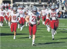  ?? Andy Cross, The Denver Post ?? Washington State freshman Max Borghi leads his team onto Folsom Field on Saturday.