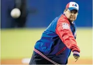  ?? PAUL CHIASSON/ THE CANADIAN PRESS ?? Mayor Denis Coderre tosses the ceremonial first pitch before the Mets-Blue Jays exhibition game last Friday.